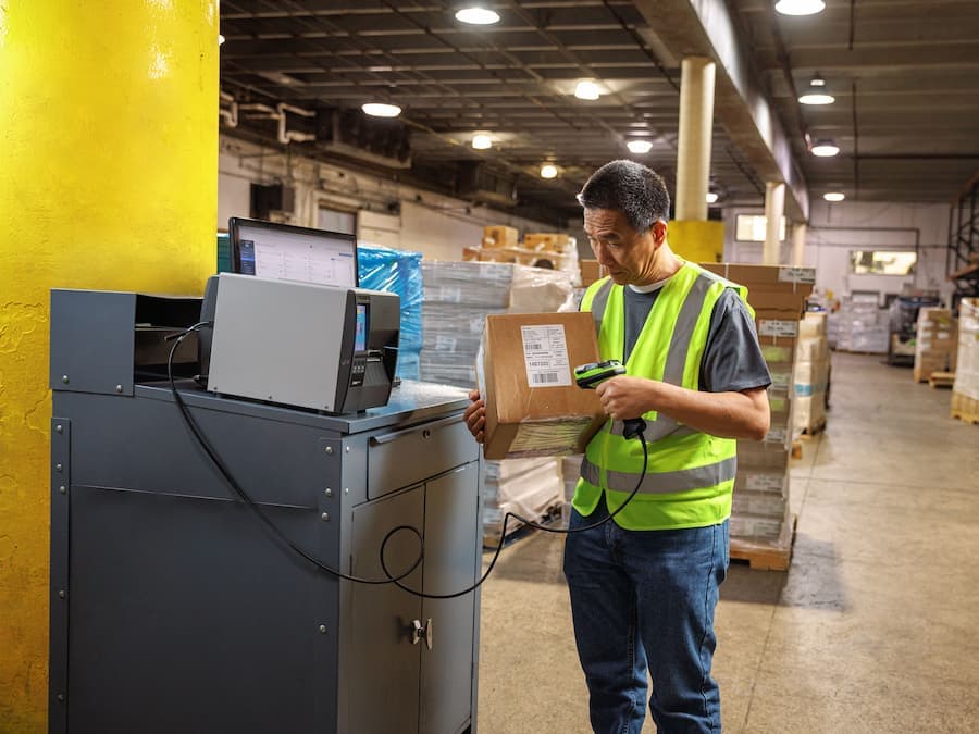 Operari escanejant una caixa en un entorn logístic